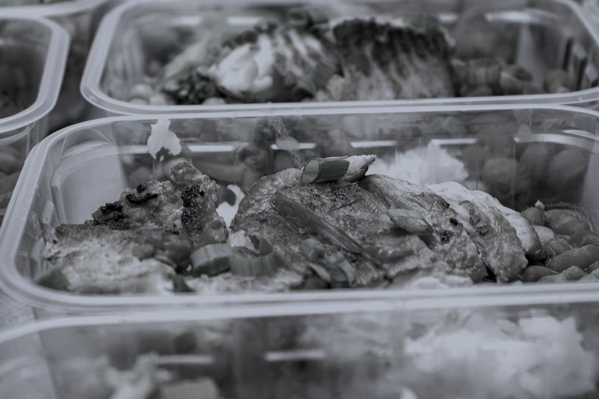 Meal prep containers of chicken, rice and vegetables lined up on a counter.