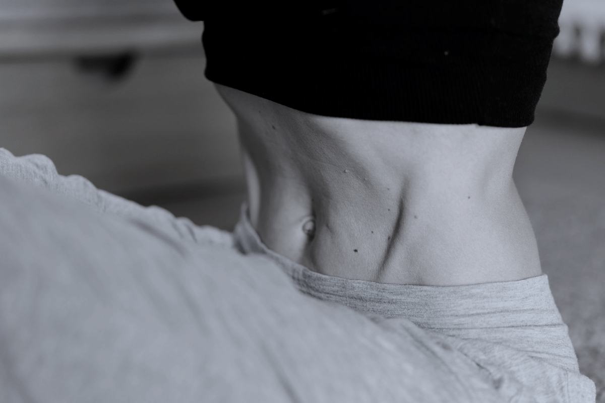 A lean midsection in sportswear, shot in soft daylight.