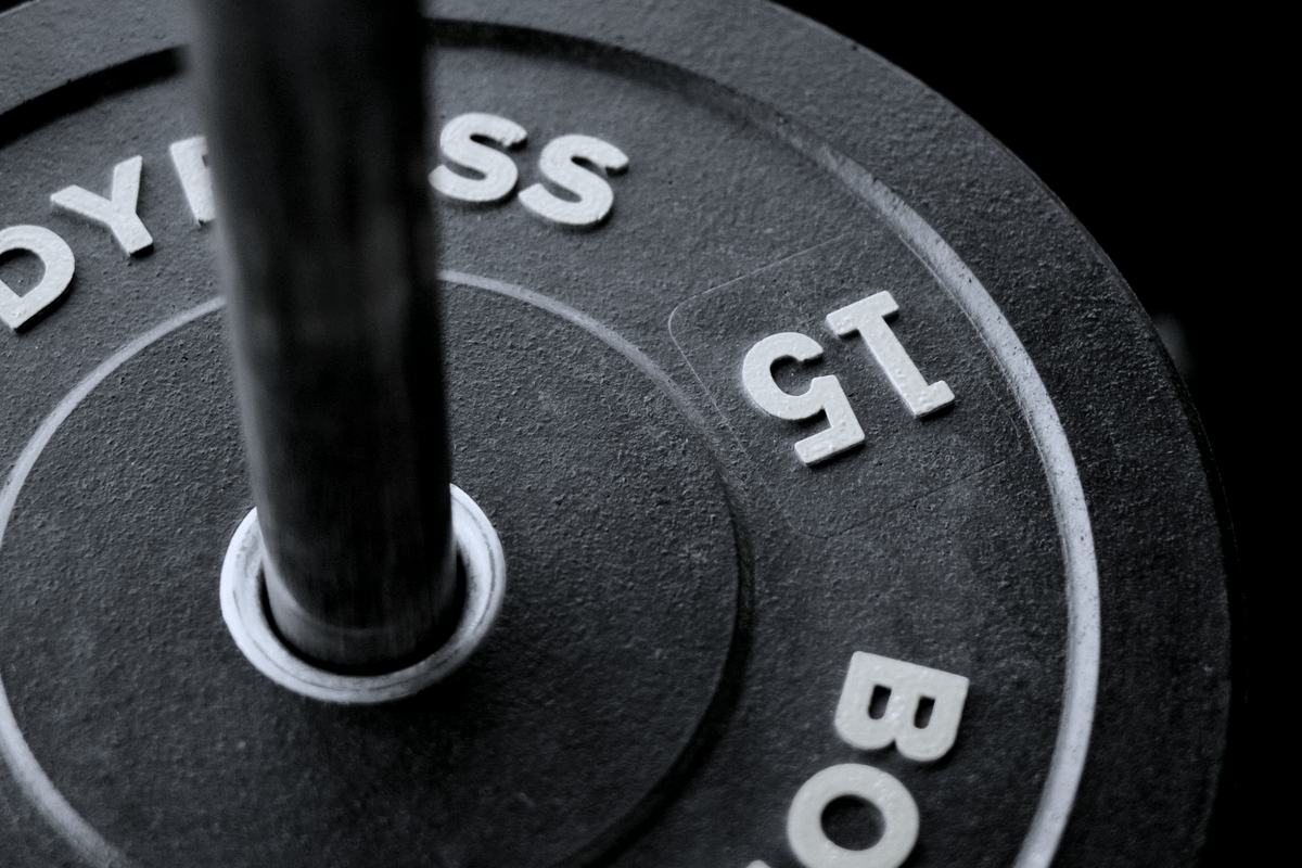 A barbell loaded with 15 kilogram plates on a gym floor.